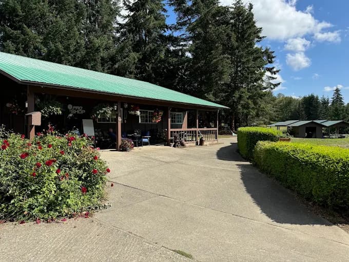Dakota Creek Golf Course pro shop with flowers and evergreen trees